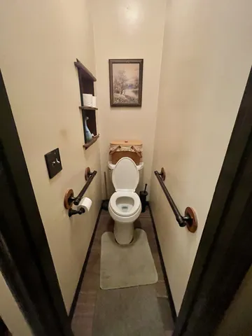 a bathroom with a toilet and a view of mirror