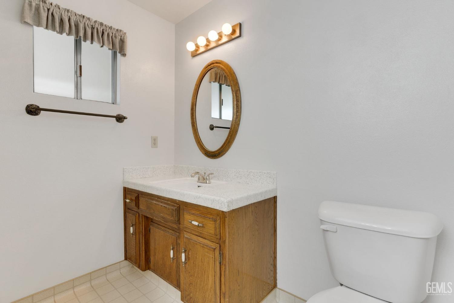 Undisclosed Address Bakersfield, CA 93309 - Photo 30 of 43 a bathroom with a toilet sink vanity and mirror