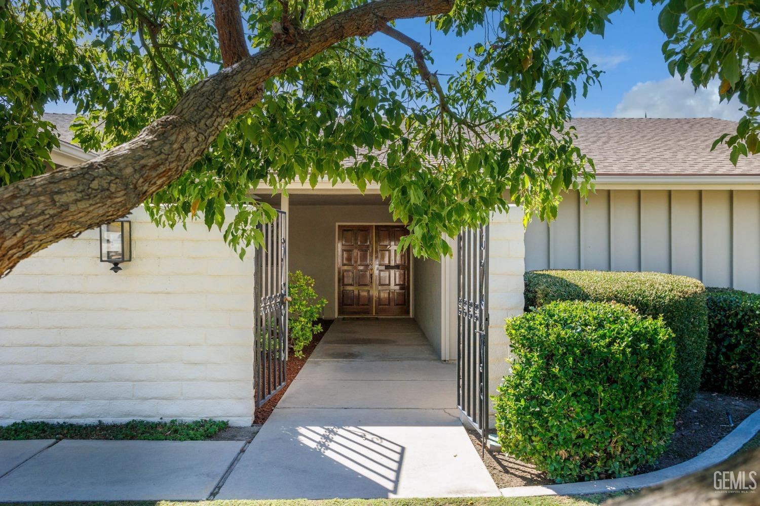 Undisclosed Address Bakersfield, CA 93309 - Photo 4 of 43 a view of a house with a small yard plants and large tree