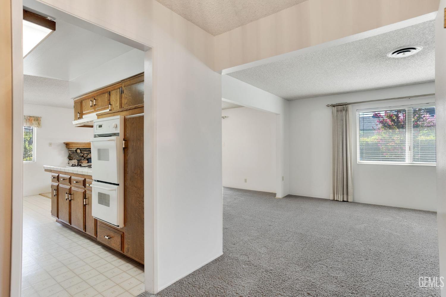 Undisclosed Address Bakersfield, CA 93309 - Photo 8 of 43 a view of a kitchen with white cabinets and wooden floor