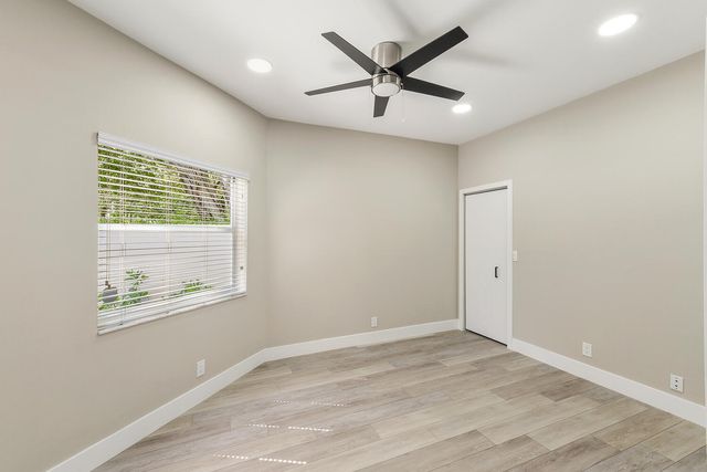 a view of a big room with wooden floor and windows