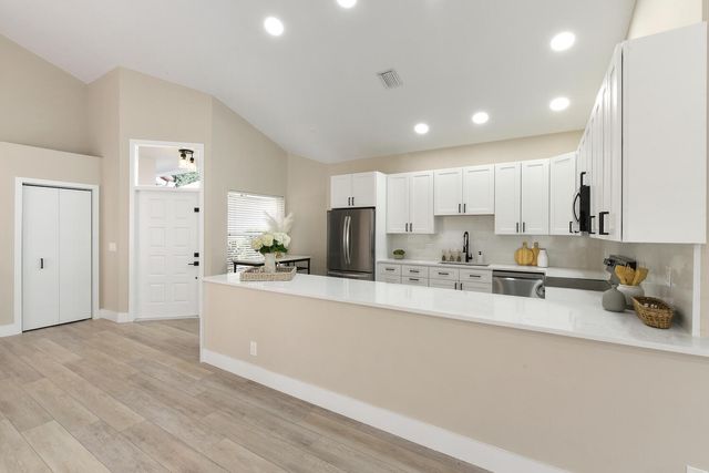 a large kitchen with kitchen island a sink a stove a refrigerator and a cabinets