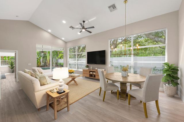 a living room with furniture a flat screen tv and a large window
