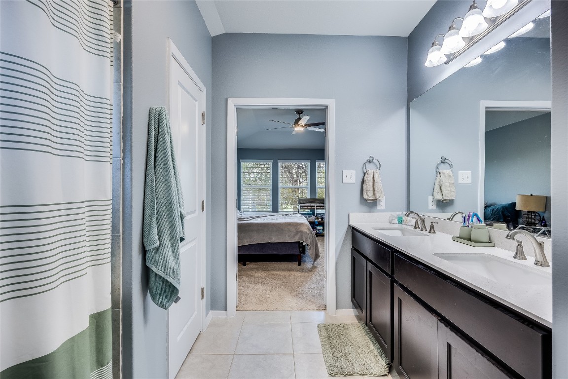 21302 Santa Rosa Avenue Lago Vista, TX 78645 - Photo 16 of 26 a en suite bathroom with a double vanity sink and a mirror