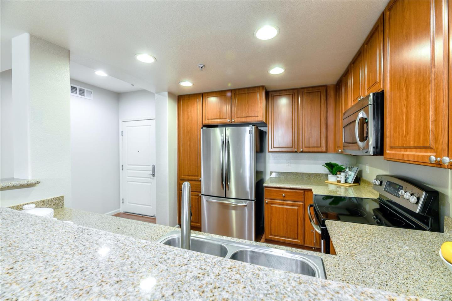 1883 Agnew Road, Unit 357 Santa Clara, CA 95054 - Photo 9 of 27 a kitchen with stainless steel appliances granite countertop a refrigerator a stove and a sink with wooden cabinets