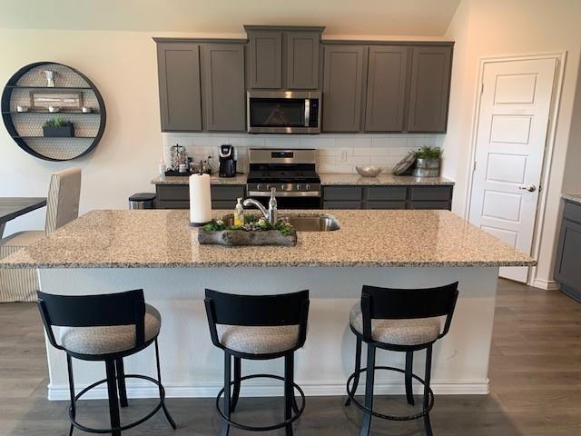 712 Feldspar Way Princeton, TX 75407 - Photo 12 of 12 Kitchen island with light granite countertop and integrated sink