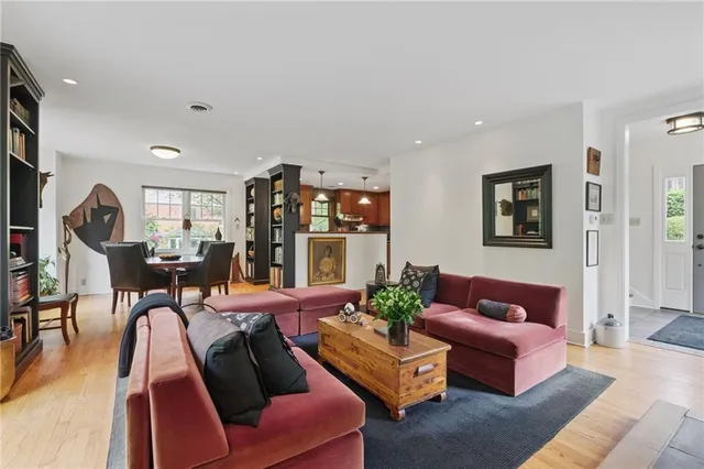 a living room with furniture kitchen view and a large window
