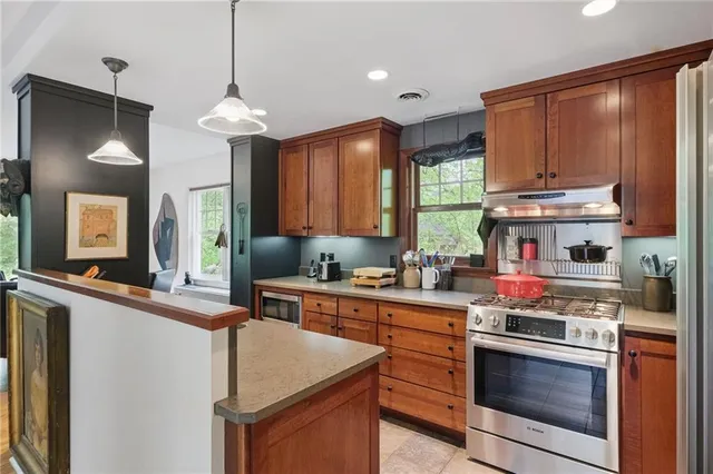 a kitchen with stainless steel appliances granite countertop a stove a sink and a refrigerator