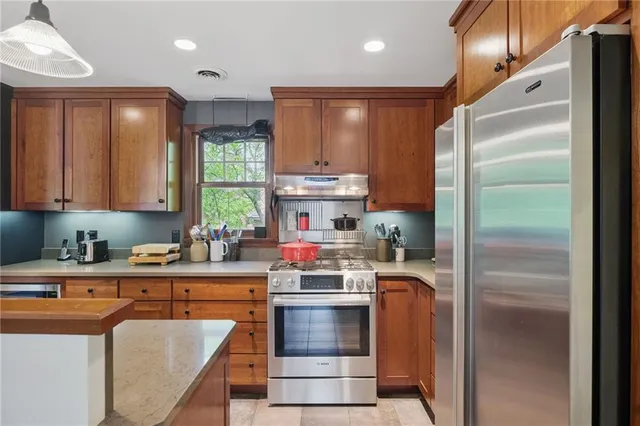 a kitchen with stainless steel appliances granite countertop a refrigerator sink and cabinets