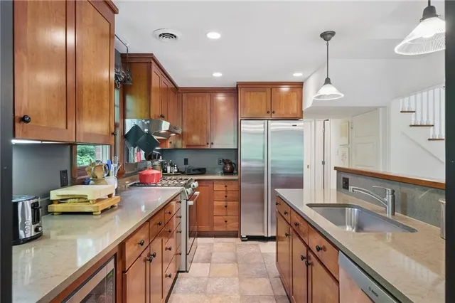 a kitchen with stainless steel appliances a sink stove and refrigerator