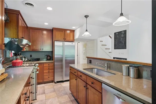 a kitchen with stainless steel appliances granite countertop a sink a stove and a refrigerator