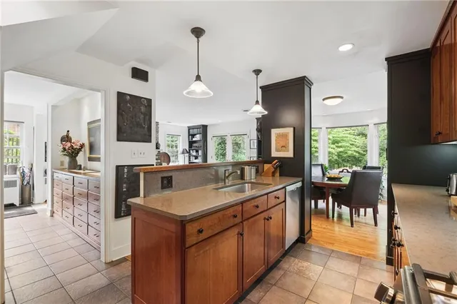 a kitchen with kitchen island granite countertop a sink counter and chairs
