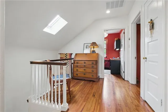a view of a hallway with wooden floor and closet