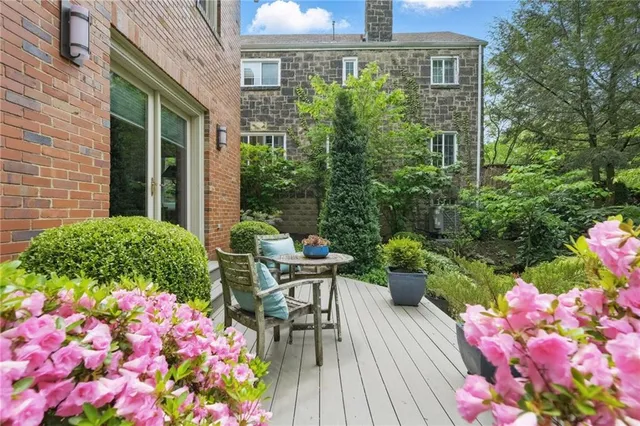 a patio with table and chairs and potted plants