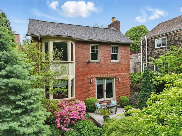 a front view of a house with a yard and plants