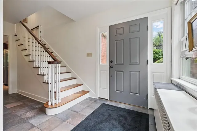 a view of a hallway with entryway wooden floor and windows