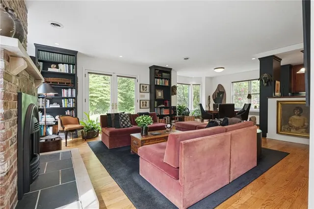 a living room with furniture a bookshelf and a window
