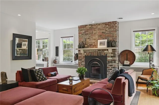 a living room with furniture a fireplace and potted plants