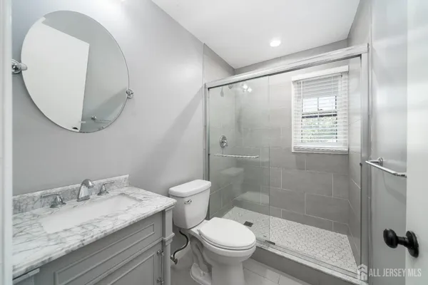 a bathroom with a granite countertop sink toilet and shower