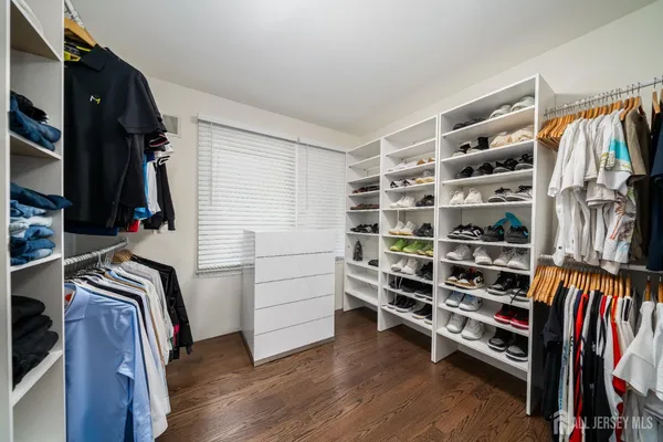 a view of walk in closet with clothes and shoes