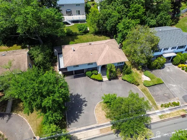 an aerial view of a house with a yard and greenery