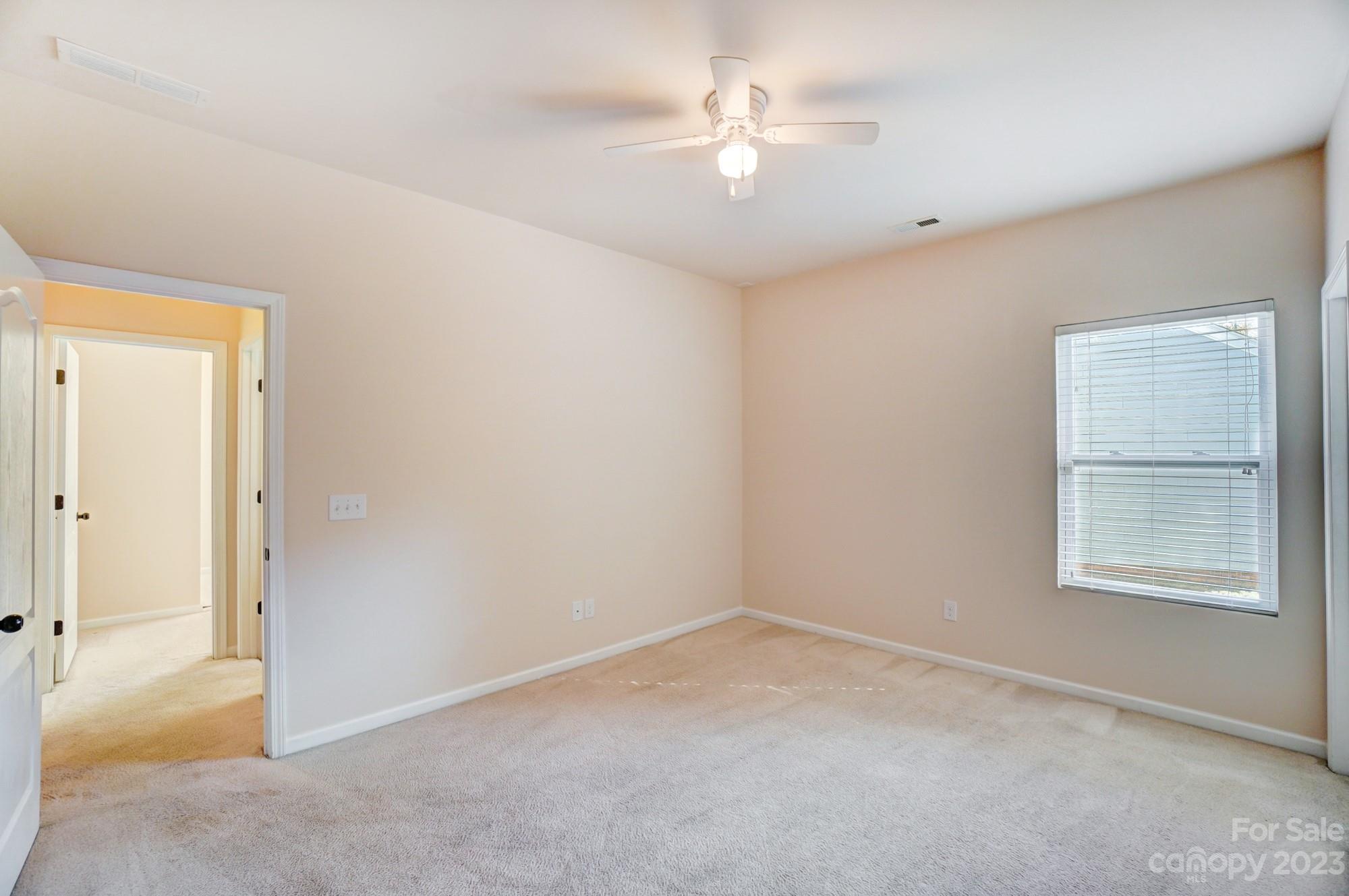 1726 Still River Way Fort Mill, SC 29708 - Photo 13 of 28 an empty room with a chandelier fan and windows