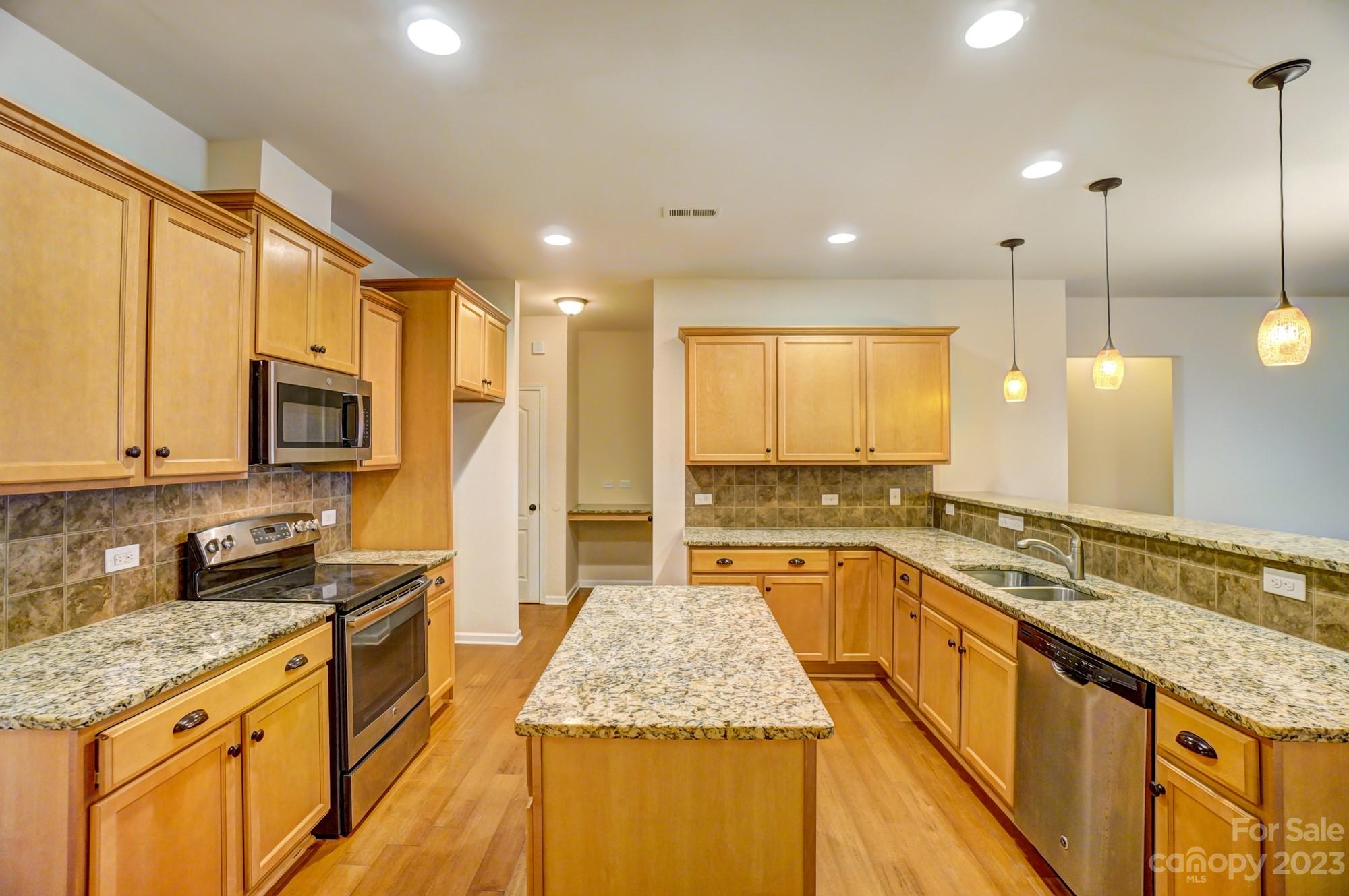 1726 Still River Way Fort Mill, SC 29708 - Photo 8 of 28 a large kitchen with stainless steel appliances granite countertop a sink stove and cabinets