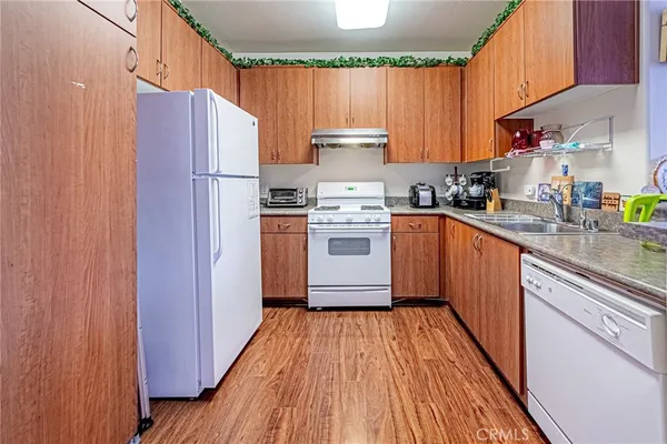 a kitchen with stainless steel appliances granite countertop a stove a sink dishwasher and a refrigerator