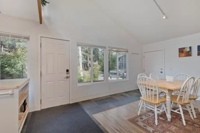 a open kitchen with stainless steel appliances granite countertop a refrigerator a sink a stove and white cabinets with wooden floor