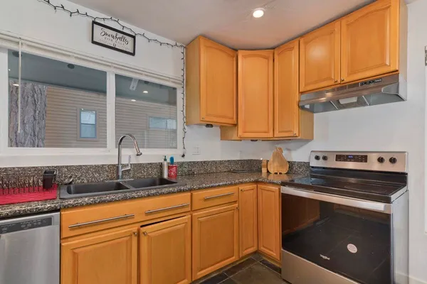 a kitchen with granite countertop stainless steel appliances a sink and counter space