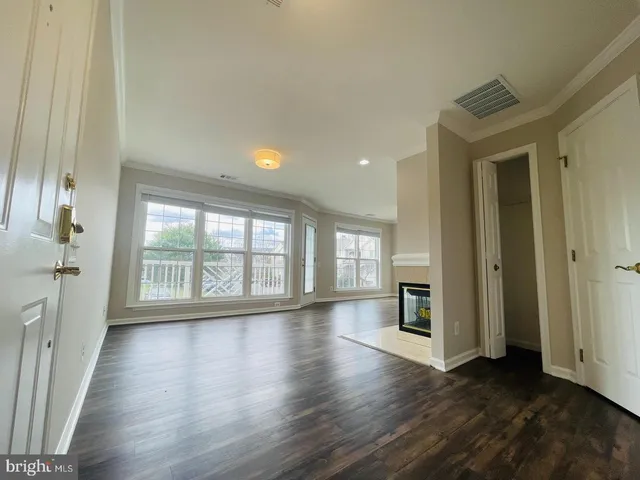 an empty room with wooden floor and a fireplace
