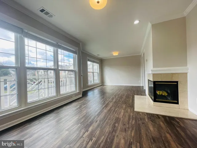 a view of an empty room with a fireplace and a window