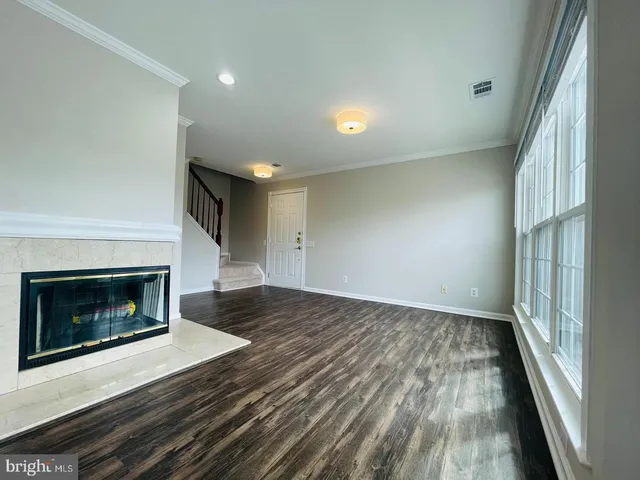 a view of an empty room and wooden floor fire place