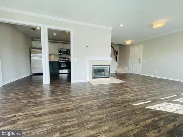 an empty room with wooden floor and a fireplace