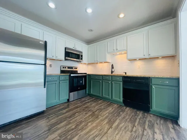 a kitchen with granite countertop a refrigerator and a sink
