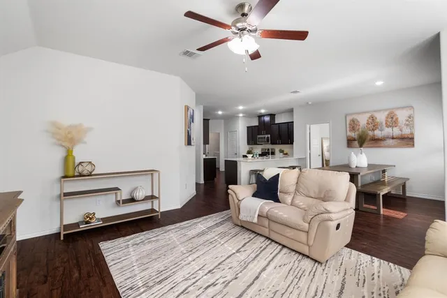 a living room with furniture and a wooden floor