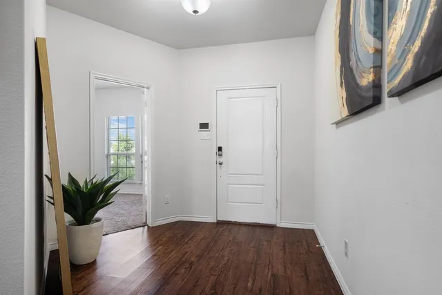 a view of a hallway with wooden floor and a potted plant