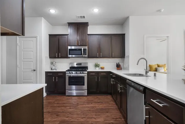 a kitchen with stainless steel appliances granite countertop a sink stove and refrigerator