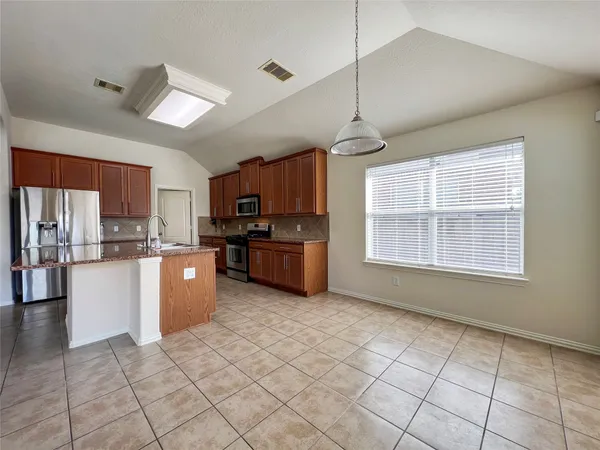 a kitchen with stainless steel appliances granite countertop a stove cabinets and refrigerator