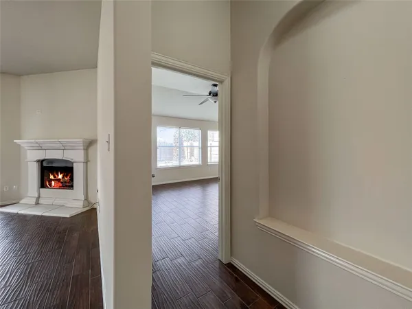 a view of a hallway with wooden floor and a fireplace