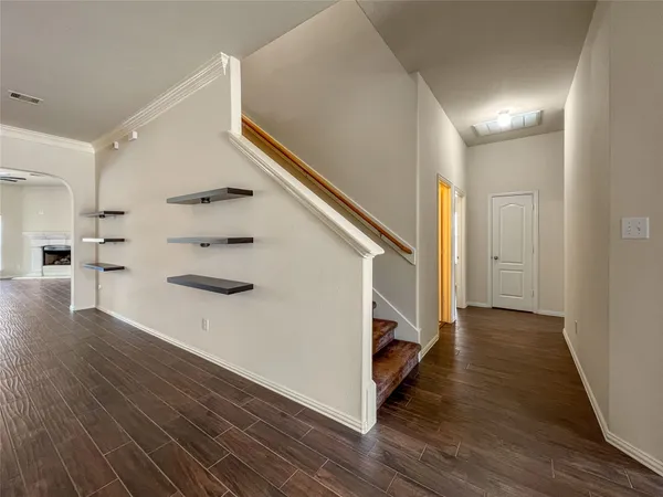 a view of a hallway with wooden floor and staircase