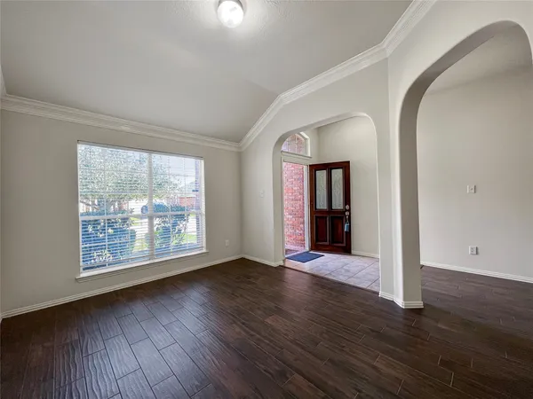 an empty room with wooden floor and mirror