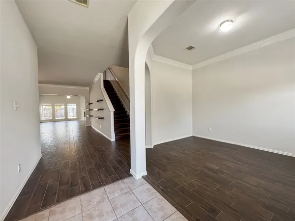 a view of an empty room with wooden floor