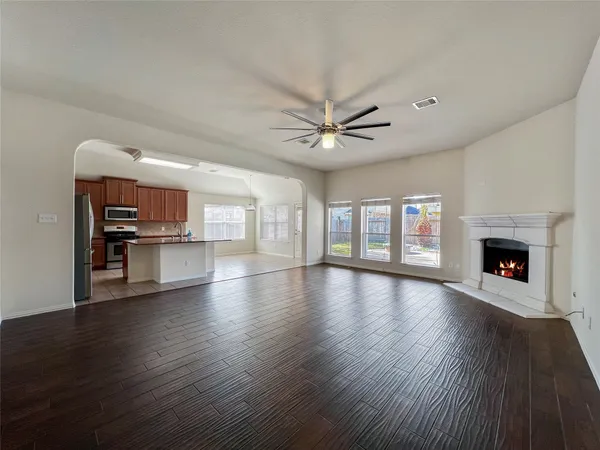a view of an empty room with a fireplace and wooden floor