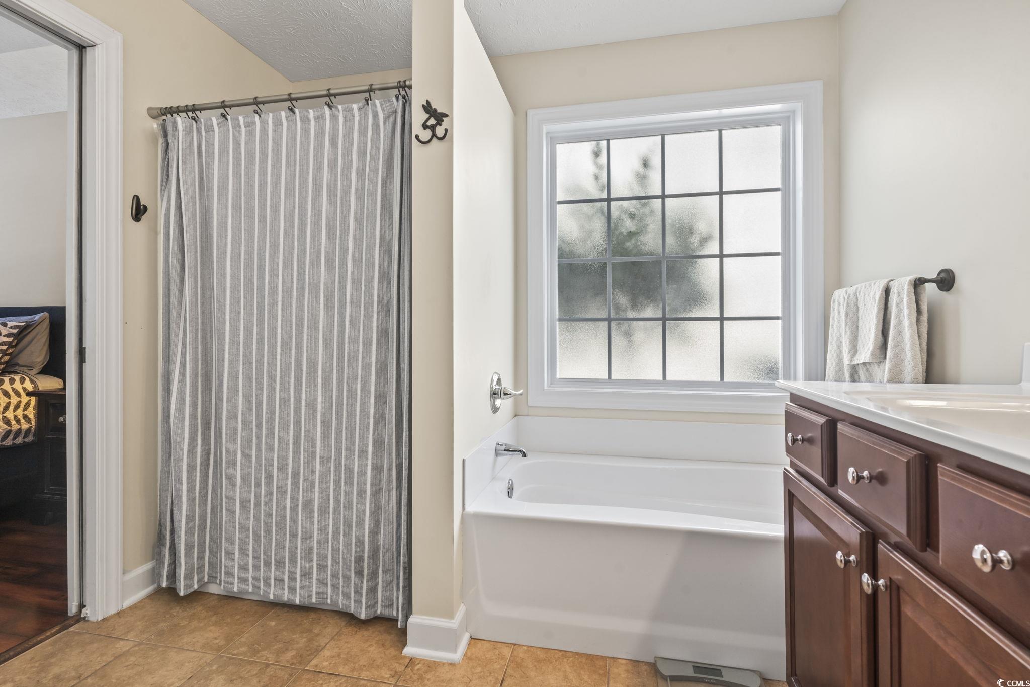 3141 Shorecrest Bay Drive Murrells Inlet, SC 29576 - Photo 20 of 30 Bathroom with vanity, tile patterned floors, a tub