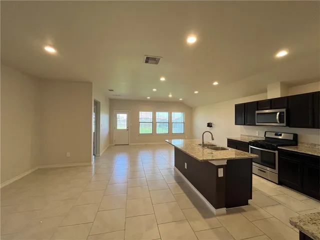 a kitchen with stainless steel appliances granite countertop a sink counter space and cabinets