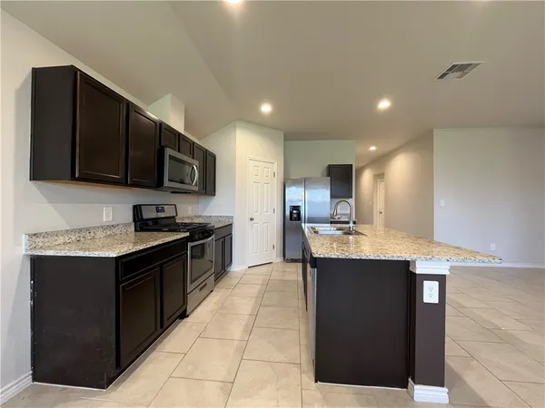 a large kitchen with stainless steel appliances and a sink
