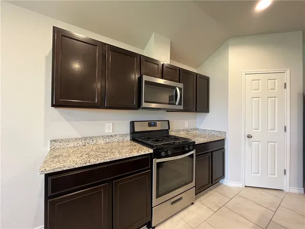 a kitchen with stainless steel appliances granite countertop a stove and a microwave