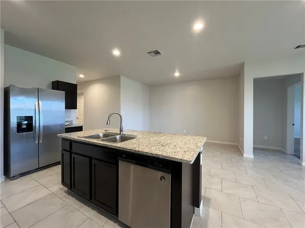 a kitchen with stainless steel appliances granite countertop a sink and a refrigerator