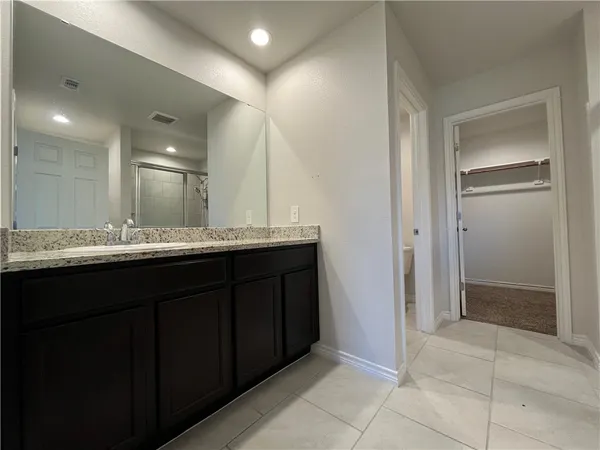 a bathroom with a granite countertop sink a mirror and a shower